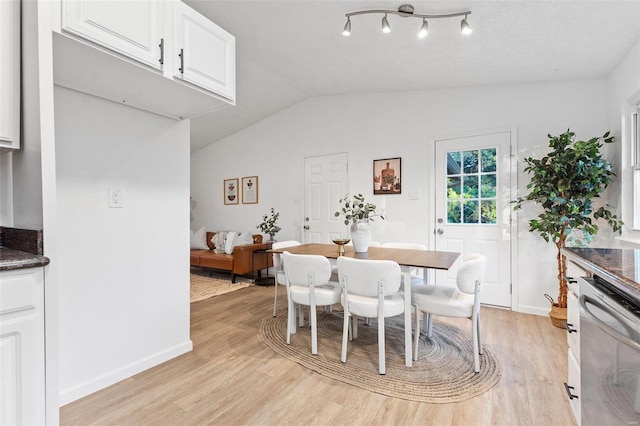 dining room with vaulted ceiling and light hardwood / wood-style floors