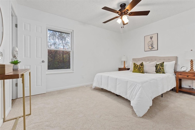 carpeted bedroom with ceiling fan and a textured ceiling