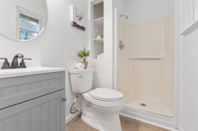 bathroom with toilet, vanity, a shower, and hardwood / wood-style floors