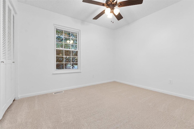 carpeted empty room featuring a textured ceiling and ceiling fan