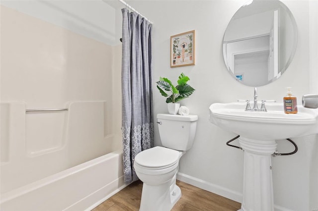 bathroom featuring toilet, shower / tub combo with curtain, and hardwood / wood-style floors