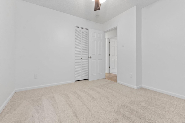 empty room featuring ceiling fan and light colored carpet