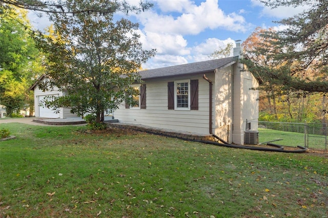 view of home's exterior with a garage, a yard, and central AC