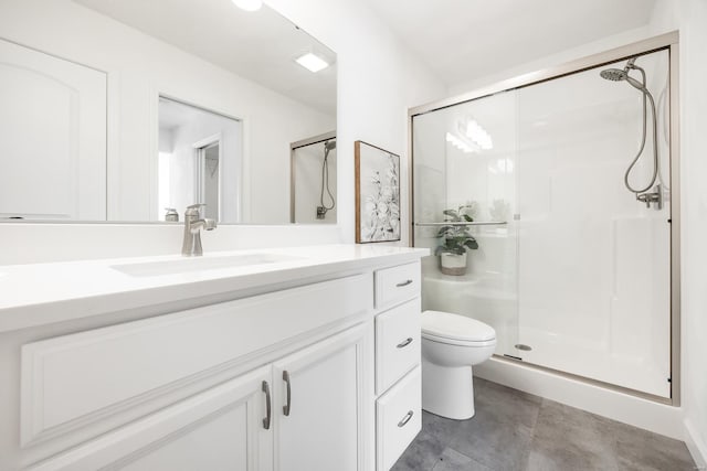 bathroom with vanity, a shower with shower door, and toilet