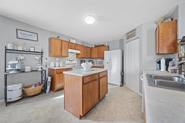 kitchen with a center island, white appliances, and sink