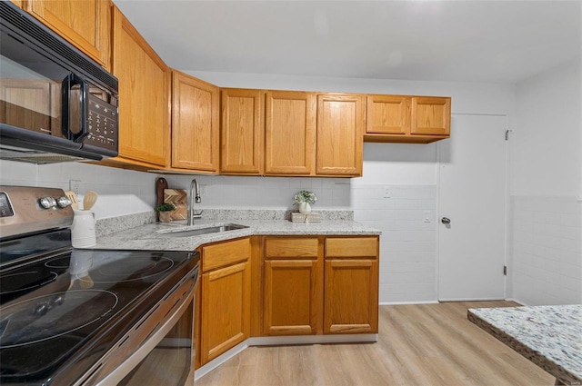 kitchen with light stone countertops, sink, light hardwood / wood-style flooring, and stainless steel range with electric cooktop