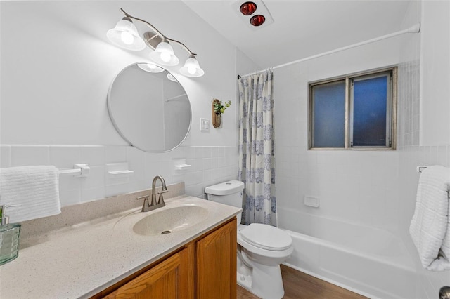 full bathroom featuring toilet, shower / bath combo with shower curtain, tile walls, wood-type flooring, and vanity