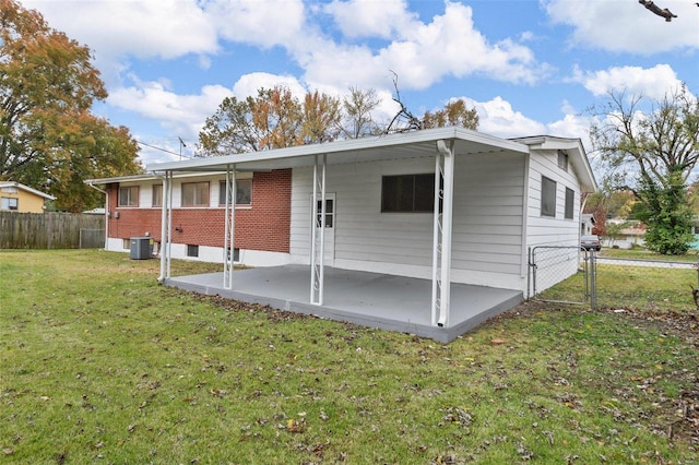 back of house with cooling unit, a yard, and a patio