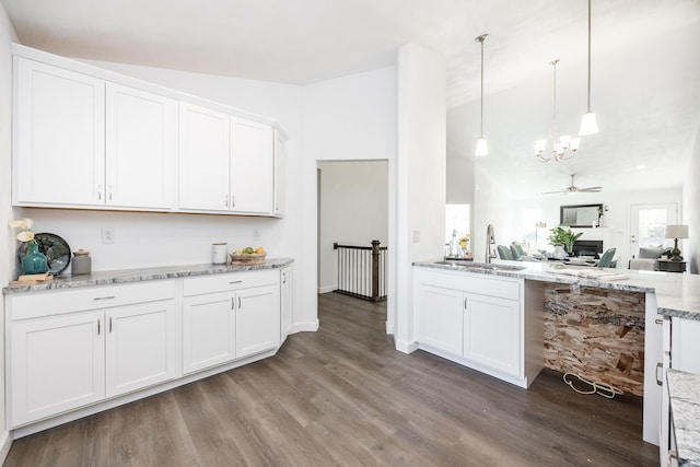 kitchen featuring white cabinets, pendant lighting, ceiling fan, and sink