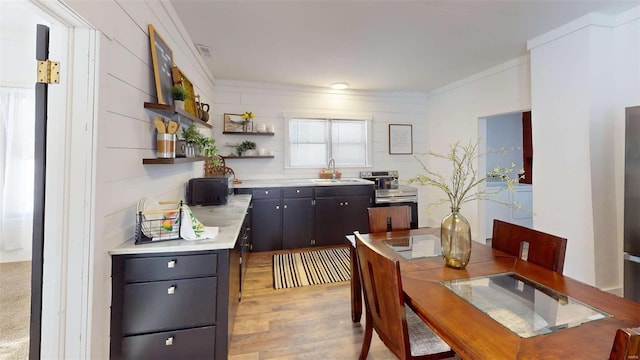 dining room featuring light hardwood / wood-style floors, crown molding, and sink