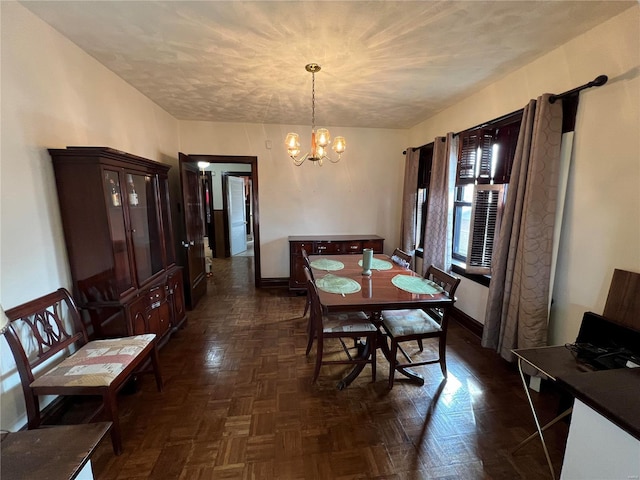 dining room with dark parquet floors and a notable chandelier