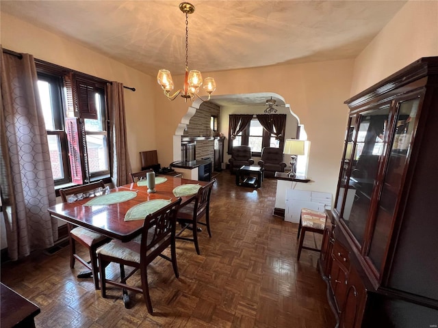 dining area with dark parquet floors and a notable chandelier