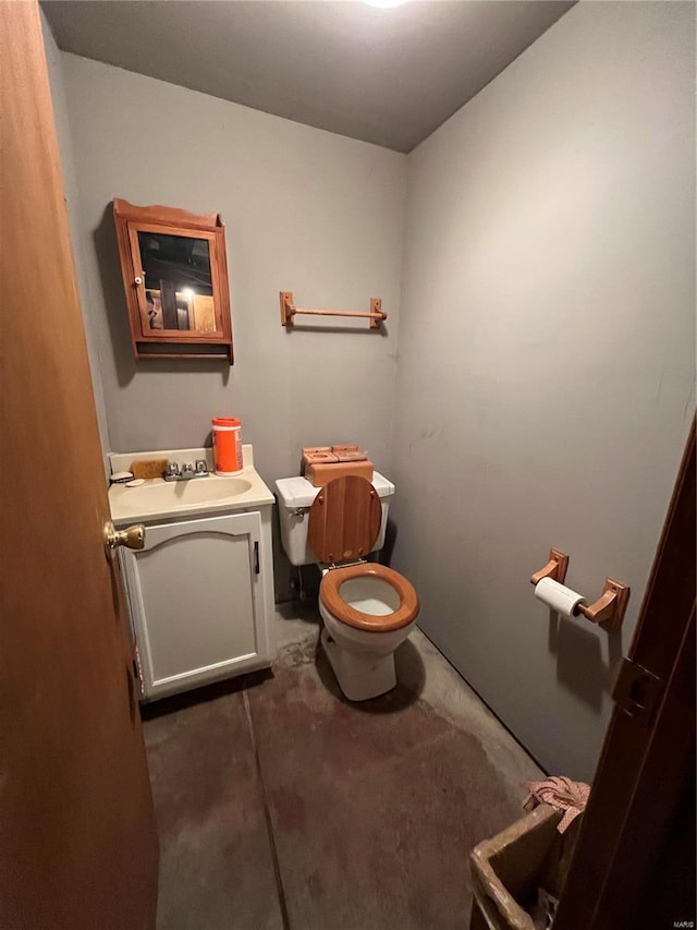 bathroom with vanity, concrete floors, and toilet