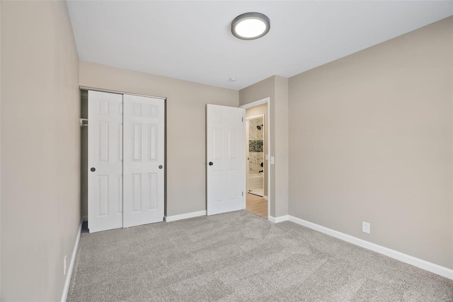 unfurnished bedroom with light colored carpet and a closet