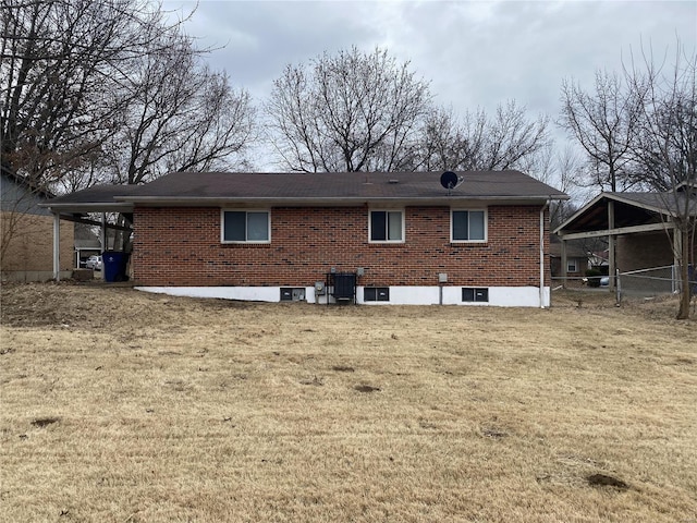 rear view of house featuring a lawn and central air condition unit