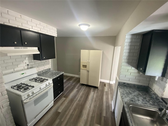 kitchen with dark hardwood / wood-style floors, sink, tasteful backsplash, and white appliances