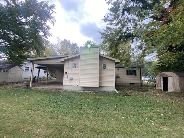 back of house featuring a lawn and a storage shed