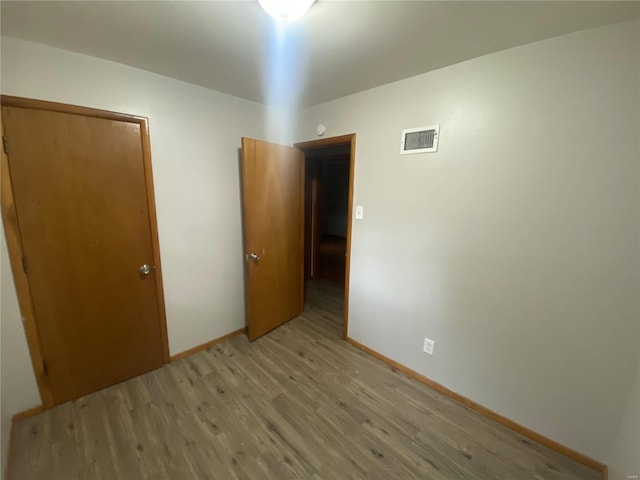 unfurnished bedroom featuring a closet and light hardwood / wood-style floors