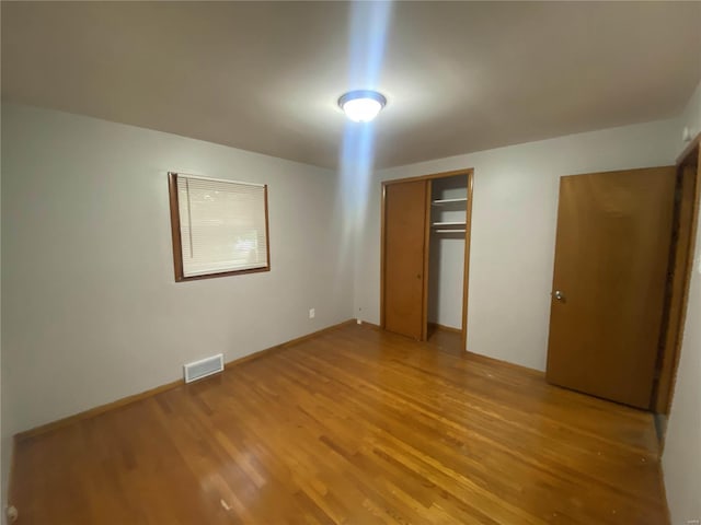 unfurnished bedroom with a closet and light hardwood / wood-style floors