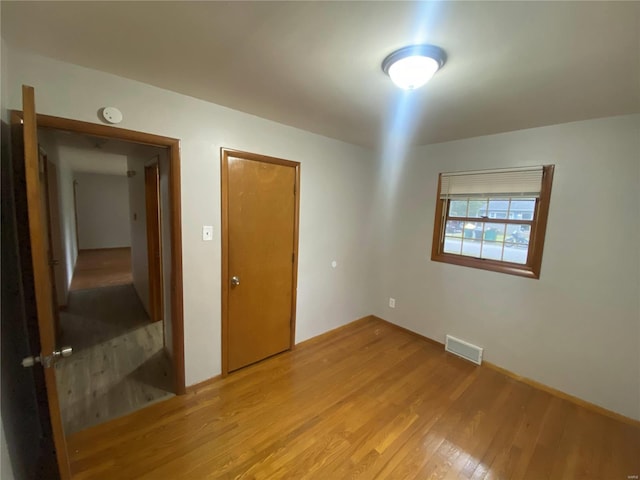 unfurnished bedroom featuring light wood-type flooring and a closet