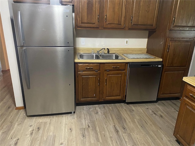 kitchen with light hardwood / wood-style floors, sink, and appliances with stainless steel finishes