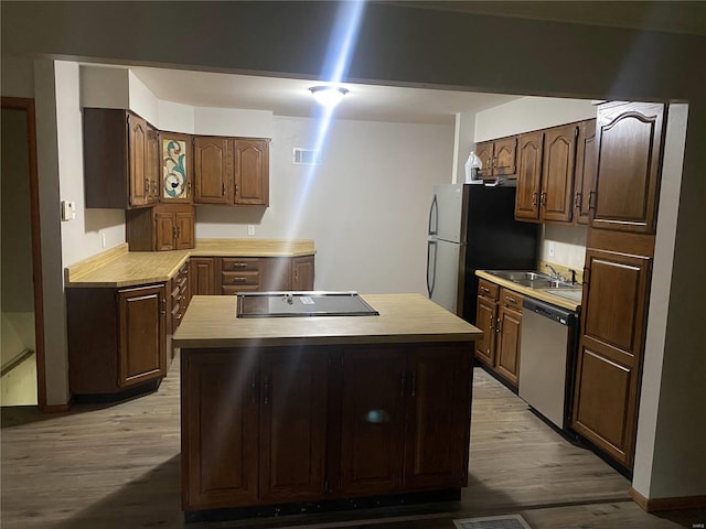 kitchen featuring dark brown cabinets, appliances with stainless steel finishes, sink, and light hardwood / wood-style floors