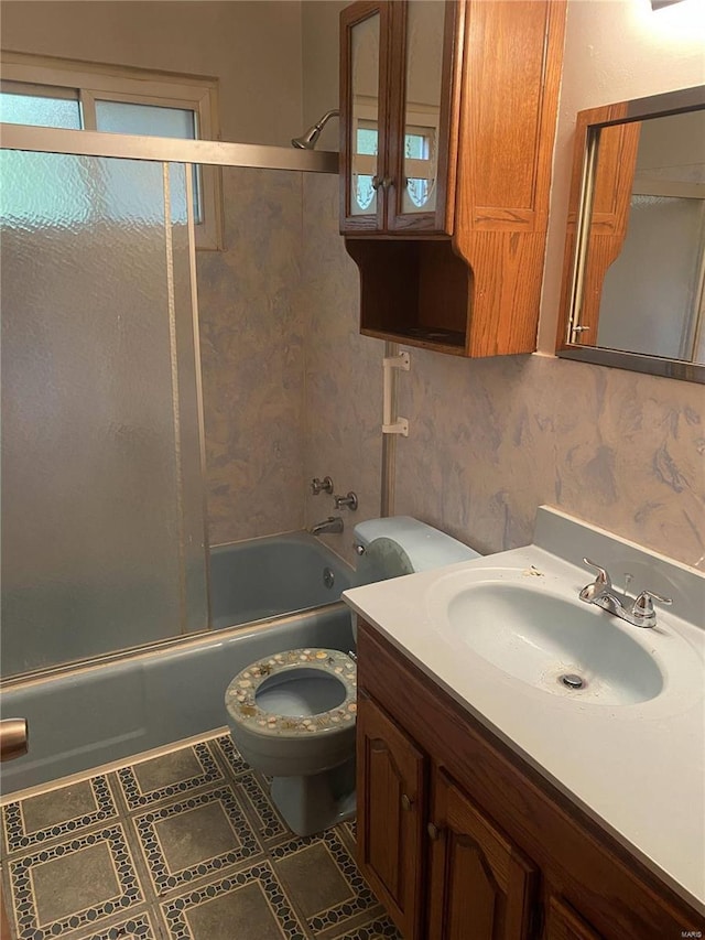 full bathroom featuring enclosed tub / shower combo, vanity, and toilet