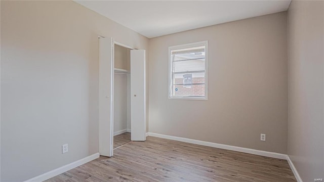 unfurnished bedroom featuring a closet and light wood-type flooring