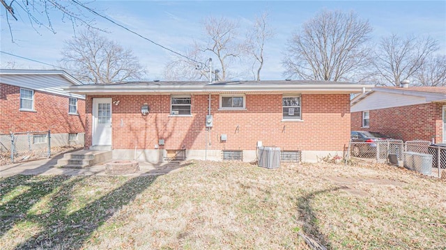 rear view of property featuring a yard and central air condition unit