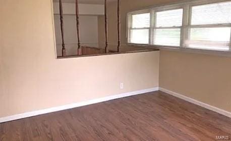 empty room with dark hardwood / wood-style flooring