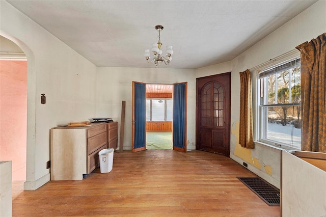 entryway with light wood-type flooring and a notable chandelier