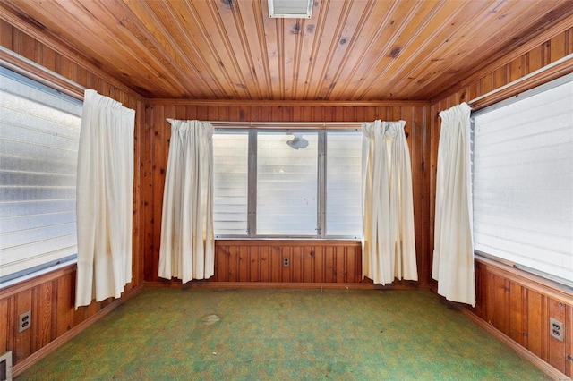 carpeted empty room with wooden walls and wooden ceiling