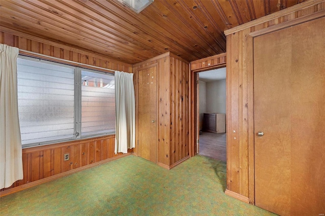 unfurnished room featuring wood walls and carpet floors