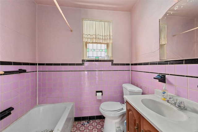 bathroom featuring vanity, toilet, tile walls, and a tub