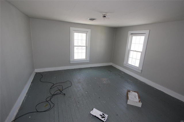 spare room with plenty of natural light and wood-type flooring