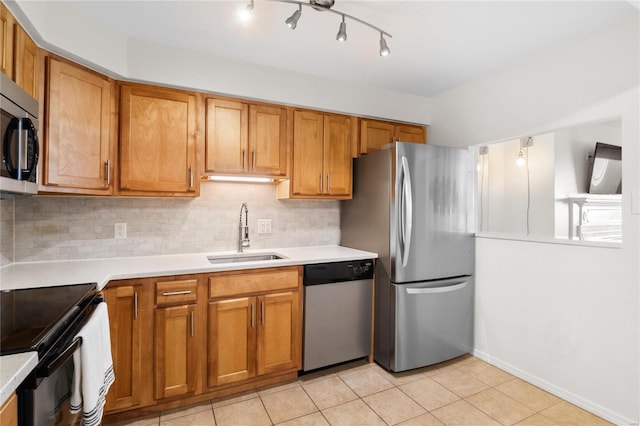 kitchen with sink, stainless steel appliances, light tile patterned flooring, and backsplash