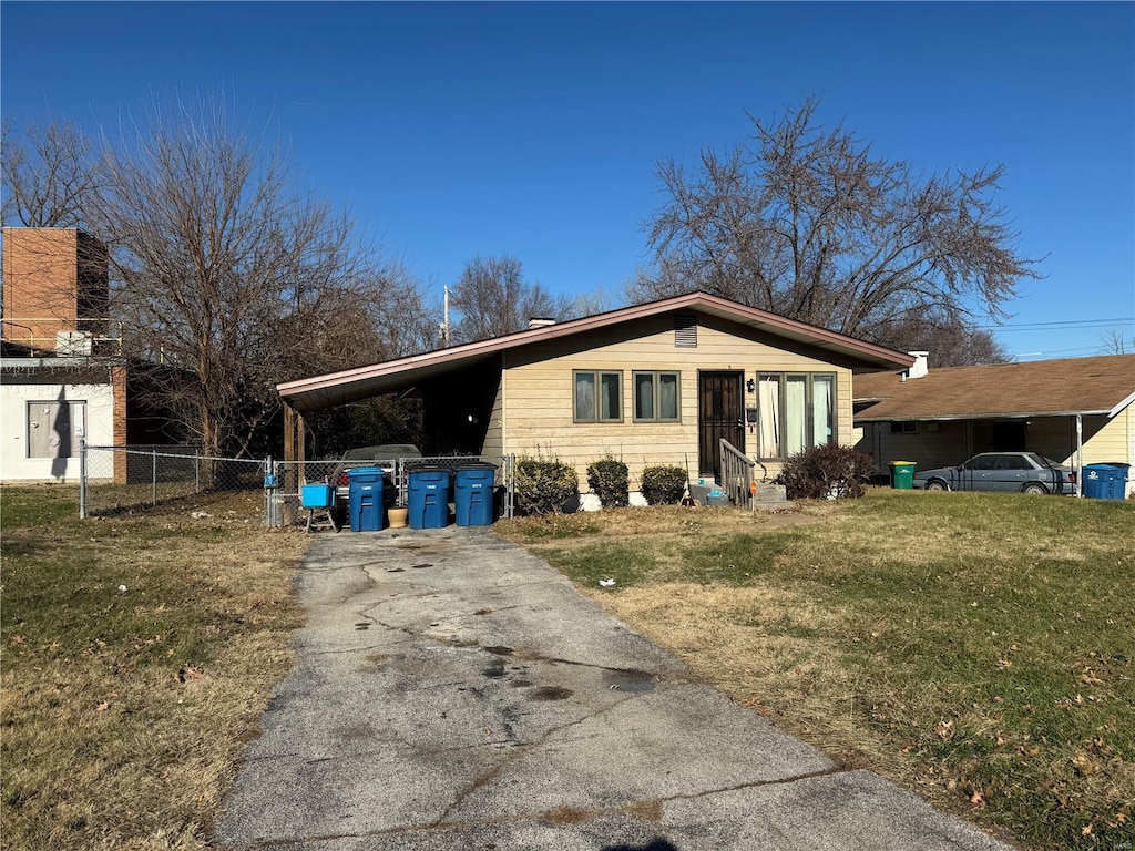 view of front of property featuring a front lawn and a carport