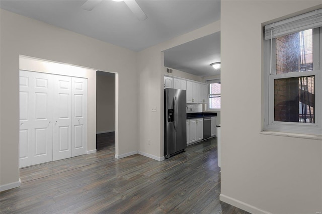 kitchen featuring stainless steel appliances, white cabinets, ceiling fan, and dark wood-type flooring