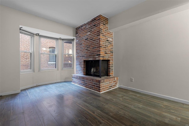 unfurnished living room featuring a fireplace and dark wood-type flooring