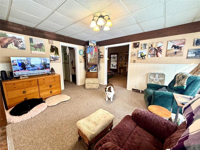 living room with a paneled ceiling and carpet floors