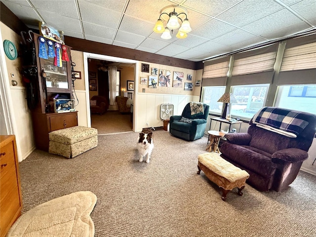 carpeted living room with a drop ceiling