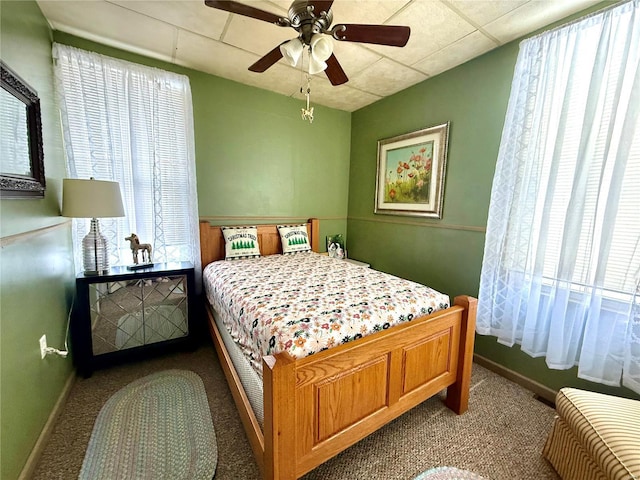 bedroom featuring ceiling fan, light colored carpet, and multiple windows