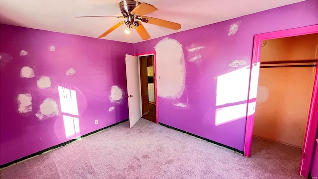 unfurnished bedroom with ceiling fan, light colored carpet, and a closet