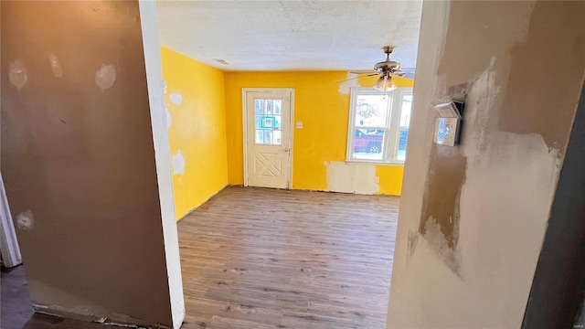 interior space with ceiling fan, a textured ceiling, and hardwood / wood-style flooring