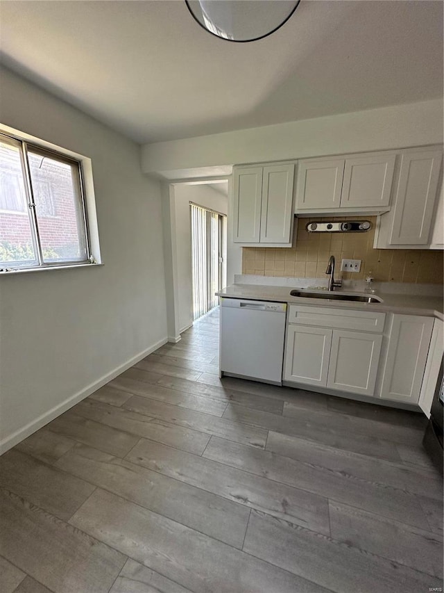 kitchen with white cabinets, white dishwasher, light hardwood / wood-style flooring, and sink