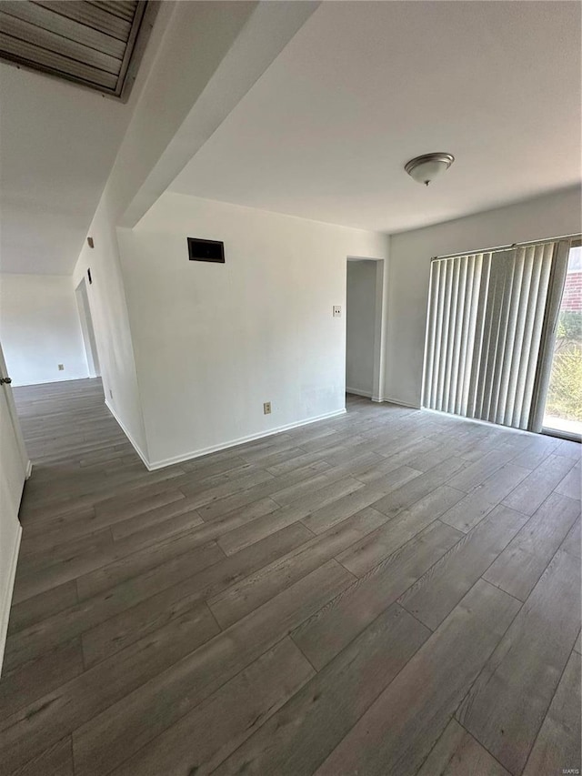 unfurnished room with dark wood-type flooring