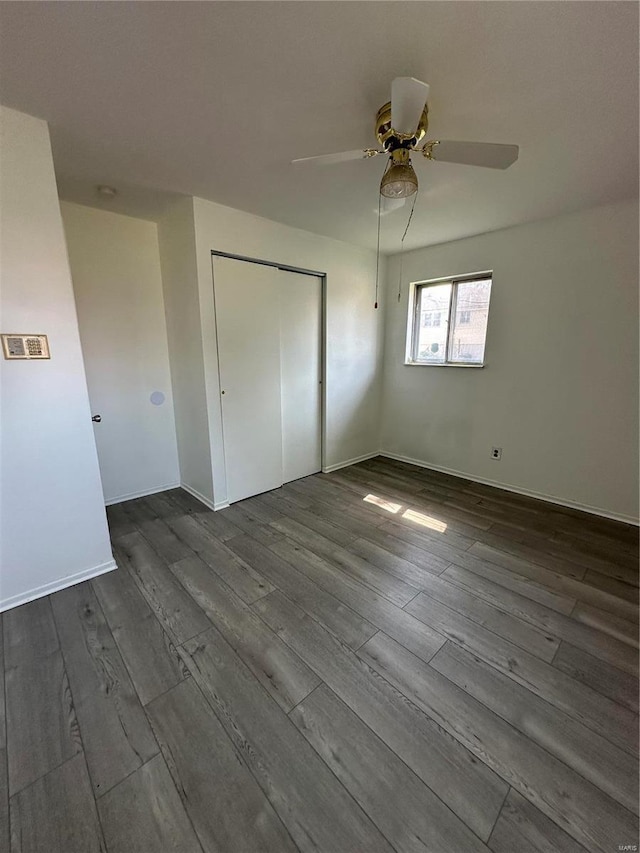 unfurnished bedroom with ceiling fan, a closet, and hardwood / wood-style flooring