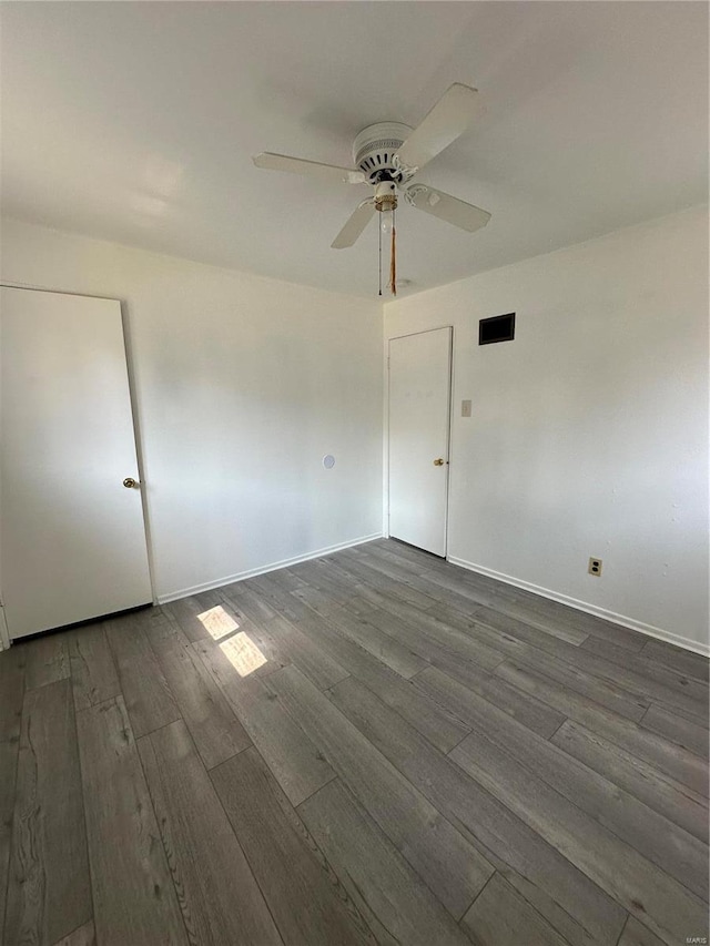 empty room featuring ceiling fan and dark hardwood / wood-style floors