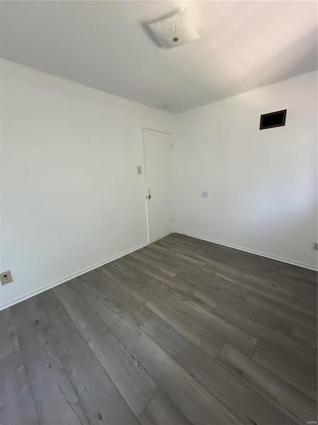 unfurnished room featuring dark wood-type flooring