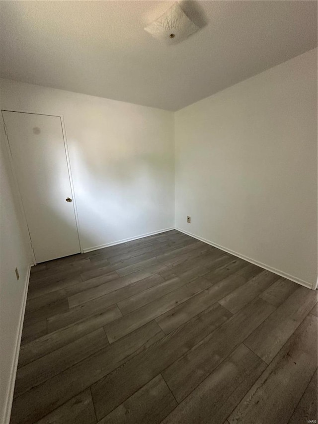 empty room with dark wood-type flooring